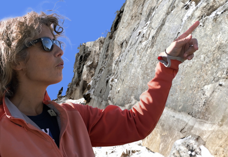 Une chercheuse montre du doigt une roche